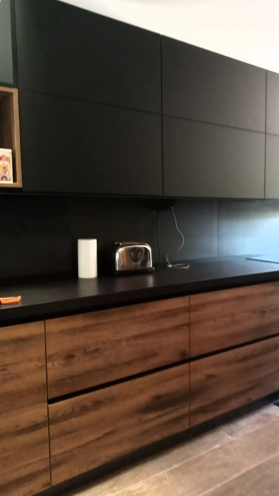 Cocina con altos negro mate sin tiradores y bajos de madera oscura