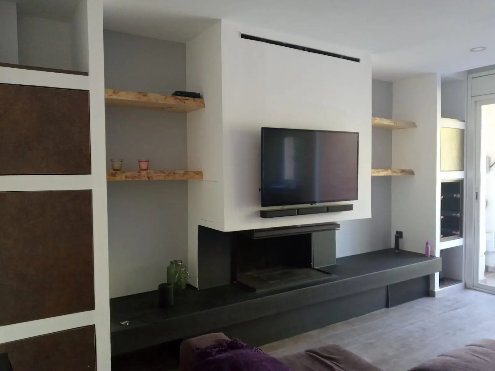 Salón con mueble de obra, chimenea integrada y estantes de madera maciza